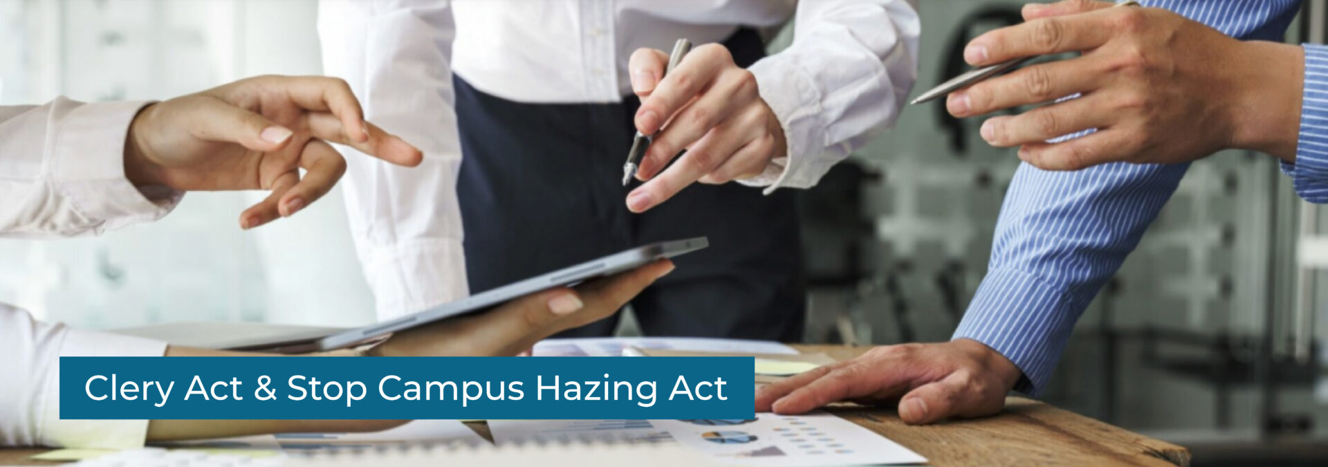 Clery Act & Stop Campus Hazing Act - A closeup shot of businessmen gathered around a tablet at a table
